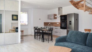 Une cuisine moderne avec un coin repas, un canapé et une petite table.