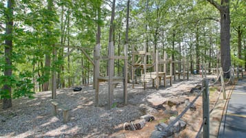 Une zone boisée avec des structures en bois, notamment un banc et une aire de jeux.
