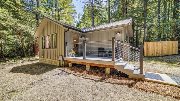 A modern cabin with a wooden exterior, a covered porch, and a staircase leading to a deck. - Peaceful Mendocino Cottage Surrounded By Redwoods (Mendocino)