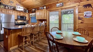 Ein Holzblockhaus-Interieur mit Küche, Essbereich und einem Schild für die Vermietung von Kanus und Paddeln.