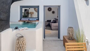 Un espace de vie extérieur moderne comprenant une piscine, un banc en bois et un fauteuil de relaxation.