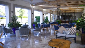 Amplio espacio interior con diversas disposiciones de asientos, incluyendo sofás y sillones, y una mesa de centro de madera en primer plano.