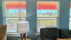 A living room with a sofa, a lamp, and a painting of a beach scene. - Pink Flamingo  (Freeport)