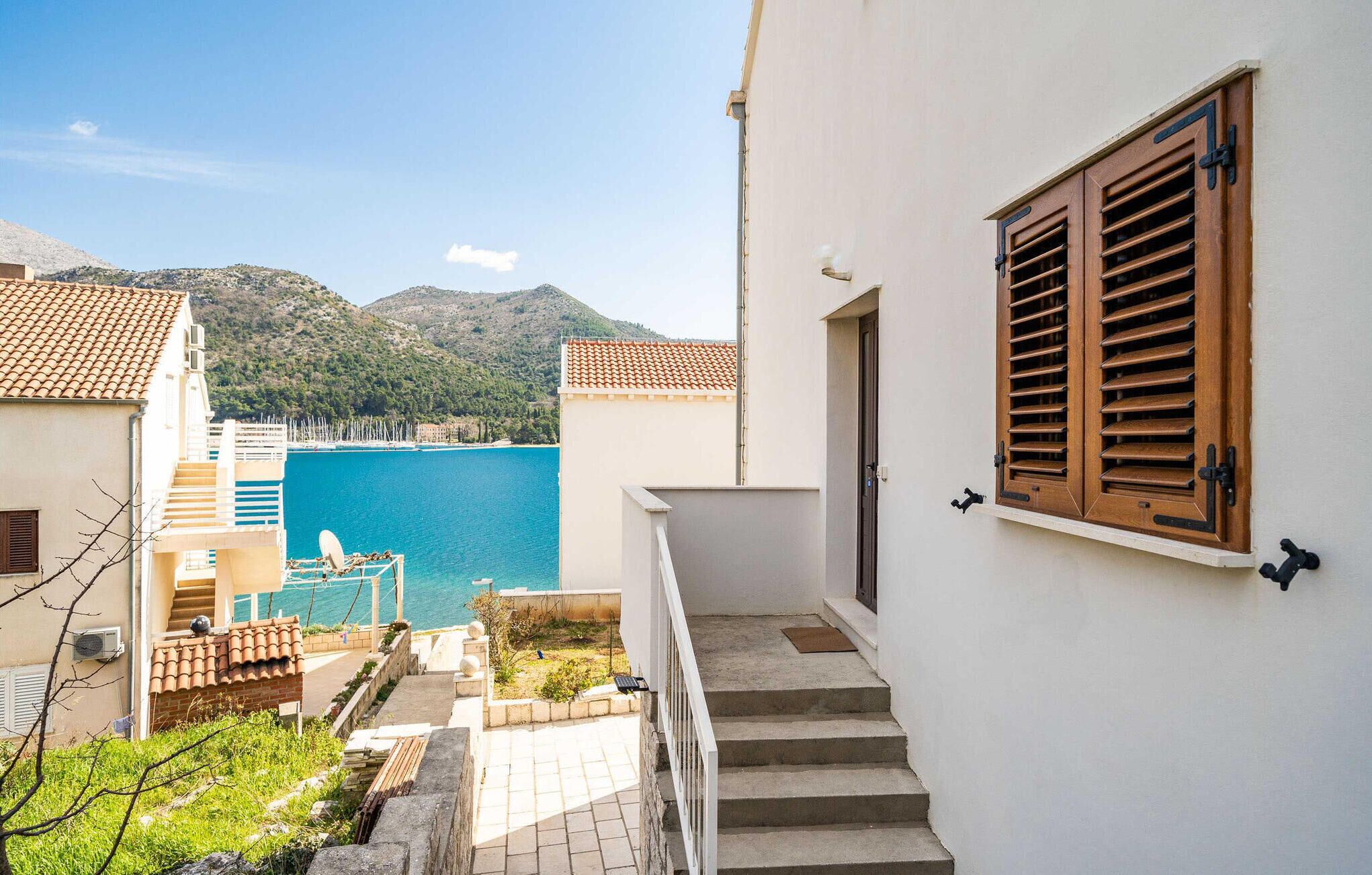 A coastal building with a view of the sea and mountains.