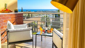 Un balcon avec une table dressée pour deux personnes, une chaise et une lampe.