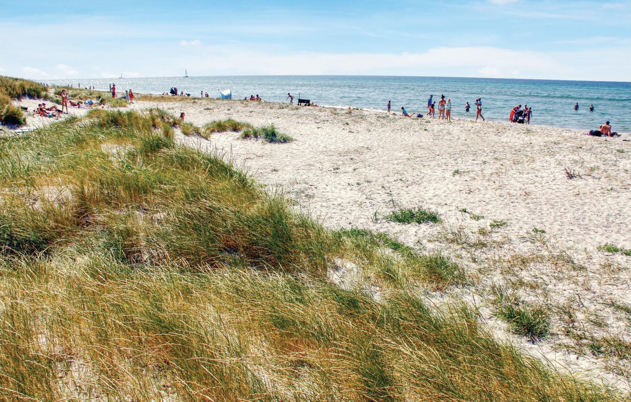 Ein Strand mit badenden und sonnenden Menschen.