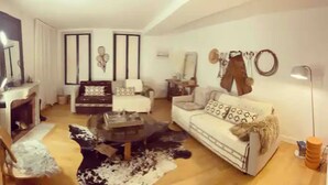 A living room with a fireplace, two sofas, a coffee table, and a rug. - The heart of Fontainebleau (Fontainebleau)
