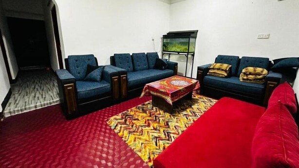 A living room with a sofa set, a coffee table, and a fish tank. - Aathil Guest House (Nilaveli)
