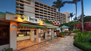 A hotel with a sign reading "Beach Walk Kau Kau to Go".