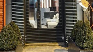 Una entrada de edificio moderno con fachada negra, puerta de vidrio y el texto "SECOND SUIT 2".