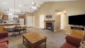 A spacious living room with a fireplace, a dining area, and a kitchen. - Two in One! Condo & Suite with Lock-off Connecting Access (Reeds Spring)