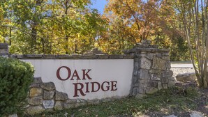 A sign reading "Oak Ridge" with a stone wall and trees in the background. - Two in One! Condo & Suite with Lock-off Connecting Access (Reeds Spring)