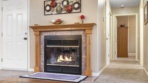 A living room with a fireplace, a door, and a hallway leading to another room. - Sweet Suite Connecting to a Charming Condo near Silver Dollar City (Reeds Spring)