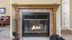A fireplace with a glass door, flanked by wooden mantels, and a rug on the floor. - Unique, Connecting Condo & Suite in StoneBridge Village (Reeds Spring)