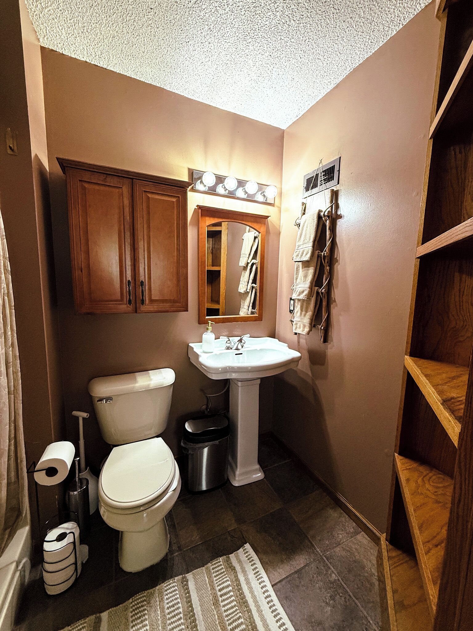 Un bagno con un WC, un lavandino e mobili in legno.