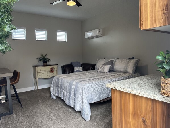 A bedroom with a bed, a desk, a ceiling fan, and a small window. - New Comfy Cozy Casita near the Lakes, Dunes & Golfing! 
Perfect Couples Getaway! (Hurricane)