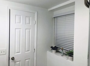 A cozy room with a traditional door, window, and potted plants.