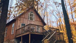 A wooden cabin with a balcony and a staircase leading to a deck. - Your 15 acres of privacy on the water- Rock Island (Rock Island)