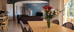 Relax in this stylish living space with a dining area, sofa, and large window offering a view of the outdoors.