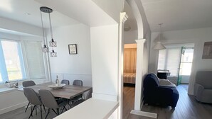 A modern, open-plan living space with a dining area, kitchen, and seating area. - Crystal Beach Getaway (Fort Erie)