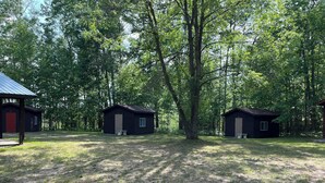 A campsite with two cabins and a covered pavilion. - Mini Cabin Paradise -15 individual cabins with Access to Private Lake (Lake)