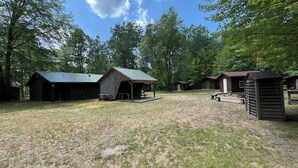 A campground with several wooden cabins, picnic tables, and a covered picnic area. - Mini Cabin Paradise -15 individual cabins with Access to Private Lake (Lake)