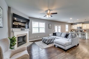 TV connectée, cheminée, livres, chaîne hi-fi