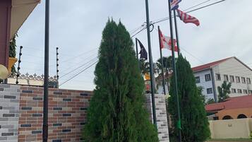 A building with a brick wall and a flagpole with multiple flags.