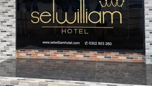 Un letrero de hotel con el nombre 'Selwilliam Hotel' e información de contacto.