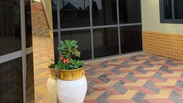 A reception area with a sign, a potted plant, and a patterned floor.