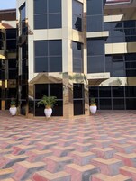 Um edifício moderno com área de recepção, janelas amplas e plantas em vasos.
