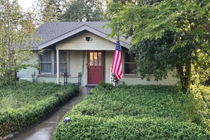 A house with a front porch, a red door, and an American flag.