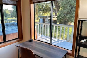 A room with a large window overlooking a deck and a stone structure.