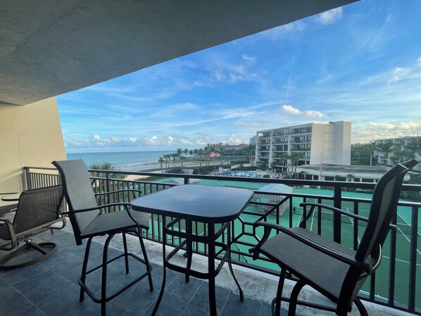 Enjoy the ocean view from this balcony with a pool and comfortable seating for two.