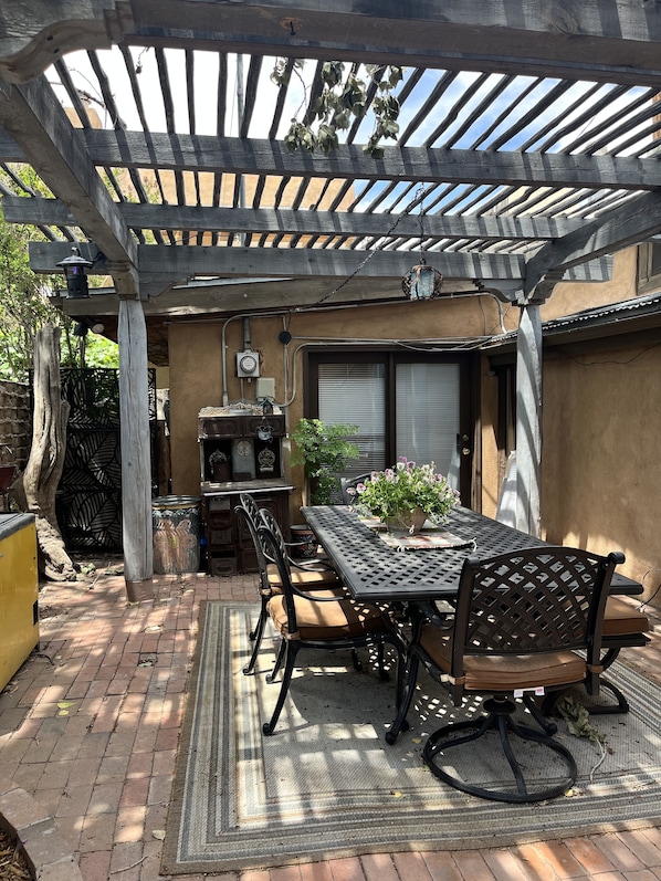 A patio with a table and chairs, a pergola, and a potted plant. - Located within in Old Town Albuquerque
Walking Distance to shops and museums (Albuquerque)