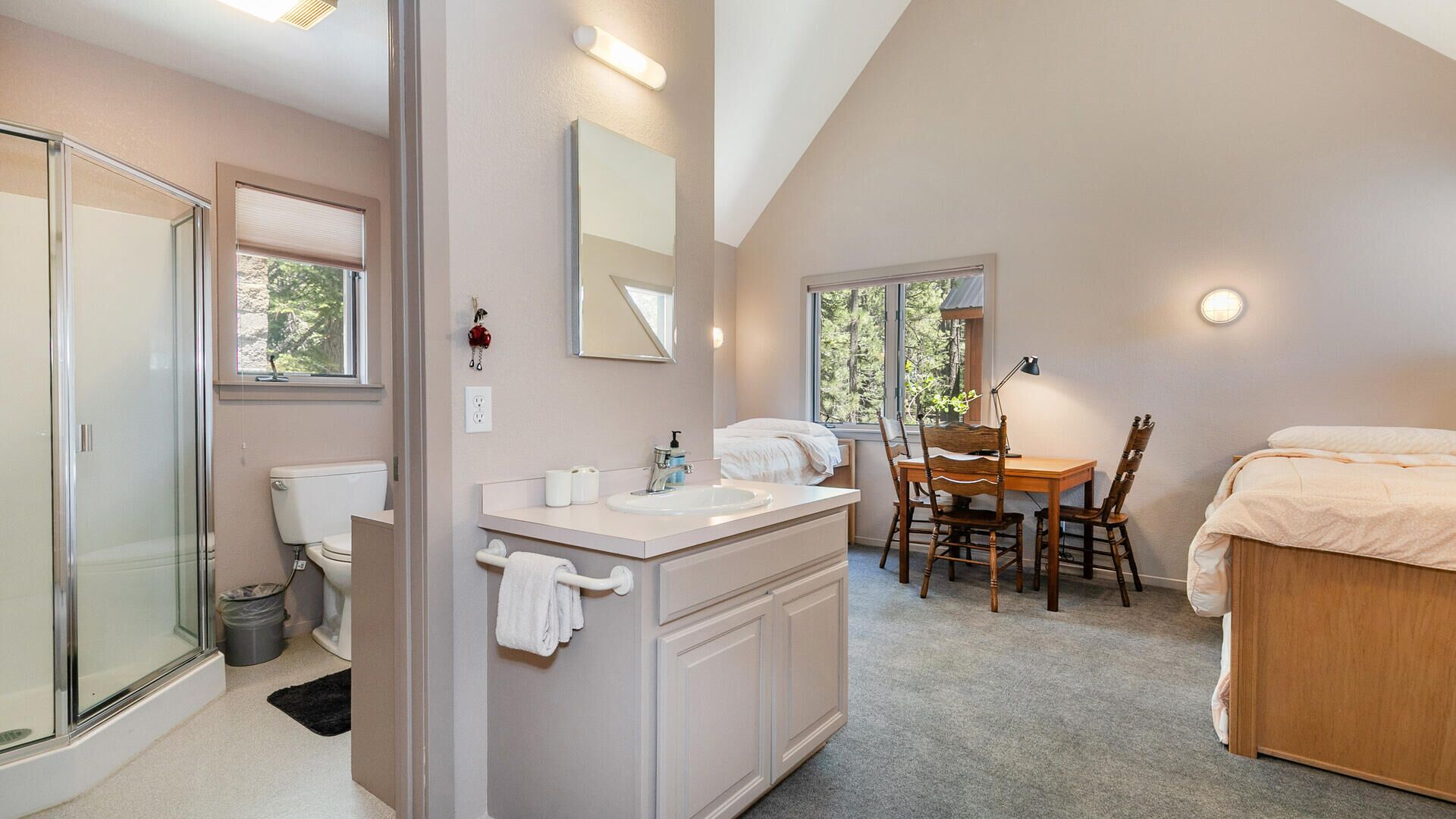 Een moderne badkamer met een douchecabine van glas, een wit wastafelmeubel en een grote spiegel.