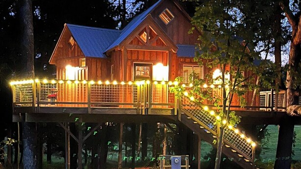A wooden cabin with a balcony and deck, surrounded by trees. - Cherry Treesort "Trevor's Layaway" (China Grove)