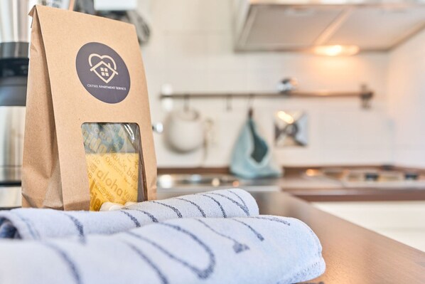 Una bolsa de papel marrón con un logotipo sobre una superficie de madera, posiblemente en una habitación de hotel.