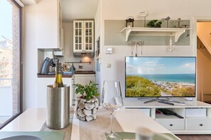 Una cocina moderna con horno empotrado, una botella de vino y un vaso sobre la encimera.
