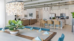 A modern kitchen with white cabinets, a central island, and pendant lighting. - Imagination at Reunion | 9 BR, Custom Built Theme Room, Game Room, Movie Theater (Kissimmee)