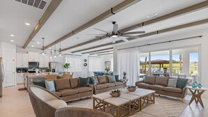 A spacious living area with a large sofa set, a coffee table, and a ceiling fan. - Imagination at Reunion | 9 BR, Custom Built Theme Room, Game Room, Movie Theater (Kissimmee)