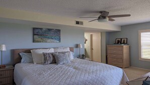 A bedroom with a bed, a ceiling fan, a painting, a wardrobe, and a window with blinds. - Beautiful 3/2 at Steven's Landing (Marco Island)