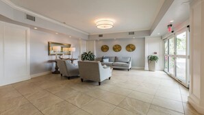 A spacious living area with a sofa, two armchairs, a coffee table, and decorative wall art.