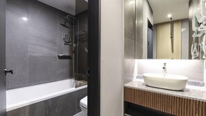 Une salle de bain moderne avec une baignoire, une douche et un lavabo.