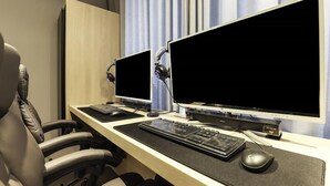 Un espace de travail équipé de deux écrans, d’un clavier, d’une souris et d’un casque audio.