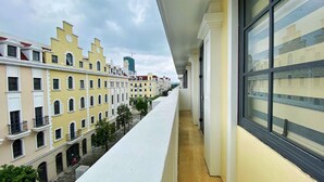 A narrow balcony with a view of a row of pastel-colored buildings. - Daily Hotel (Bai Chay)