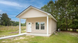 A small, single-story building with a covered porch, a front door, and two windows. - Modern Mid-Town Luxury Hideaway  (Savannah)