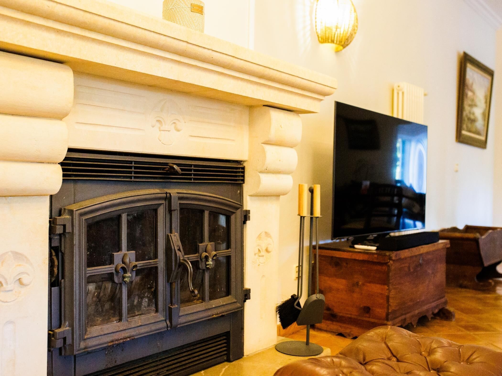 Una sala de estar con chimenea, televisor y un mueble de madera.