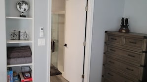Een slaapkamer met een bed, een kaptafel, een kledingkast en een deur naar een badkamer.