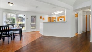 A spacious kitchen with a breakfast bar, wooden cabinets, and a view to the outside. - Spacious 2BR home near Downtown Dallas and State Fair of Texas (Dallas)